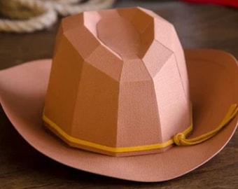 May include: A brown cowboy hat with a yellow band and a brown tassel. The hat is made of a textured material and has a geometric design.