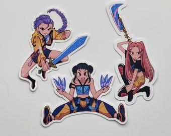 May include: Three die-cut stickers featuring anime-style illustrations of female characters in action poses. One character has purple hair and a yellow jacket, wielding a blue sword. Another has pink hair and a large weapon. The third has black hair and blue energy.