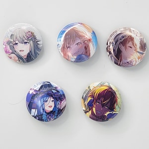 Puede incluir: Cinco botones redondos y brillantes con ilustraciones de personajes de estilo anime. Los botones presentan retratos coloridos de varios personajes con cabello y rasgos faciales detallados. Los fondos son una mezcla de colores claros.