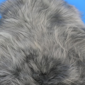 Owcza skóra, długowłose owcze części w kolorze grafitowym. Oryginalne owcze części do dekoracji i rzemiosła. Futro do rękodzieła. Kolorowa owcza skóra.