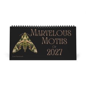 Puede incluir: Un calendario de pared con espiral negra titulado Marvelous Moths of 2027. La portada presenta una ilustración detallada de una polilla halcón de lima verde y marrón a la izquierda, con el texto impreso en una fuente serif grande a la derecha.