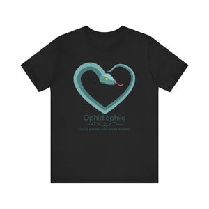 May include: Black t-shirt featuring a teal snake in a heart shape with the word "Ophidiophile" and the definition "(n.) a person who loves snakes". The snake has a red tongue and yellow eyes.