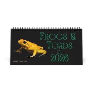 May include: A black spiral-bound calendar featuring a golden poison frog. The calendar's cover has the text "FROGS & TOADS OF 2026" in green, with "Golden Poison Frog" at the bottom.