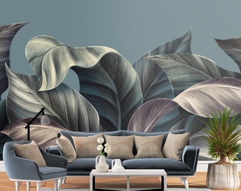 May include: A living room interior design with a blue velvet sofa and armchair, a coffee table, and a potted plant. The wall is decorated with a large-scale wallpaper featuring a stylized illustration of tropical leaves in shades of green, white, and blue.