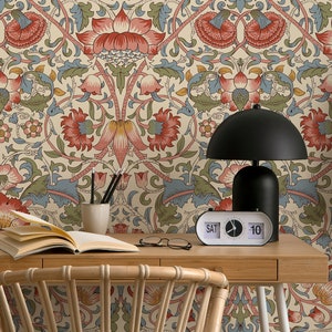 Puede incluir: Un escritorio de oficina en casa con papel tapiz de estampado floral, una planta en maceta, un libro, un par de gafas, una l&aacute;mpara y un reloj que marca "S&Aacute;B 10".