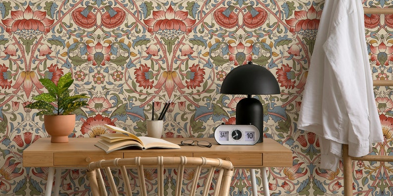 Puede incluir: Un escritorio de oficina en casa con papel tapiz de estampado floral, una planta en maceta, un libro, un par de gafas, una l&aacute;mpara y un reloj que marca "S&Aacute;B 10".
