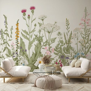 May include: Two white couches with floral patterned wallpaper behind them. The wallpaper features a variety of flowers and plants in shades of pink, green, and yellow.
