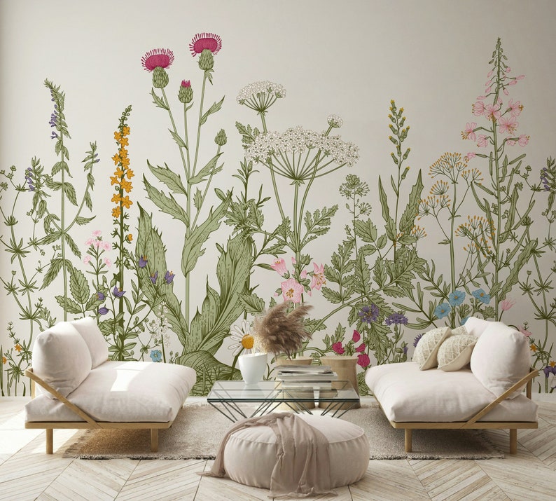 May include: Two white couches with floral patterned wallpaper behind them. The wallpaper features a variety of flowers and plants in shades of pink, green, and yellow.