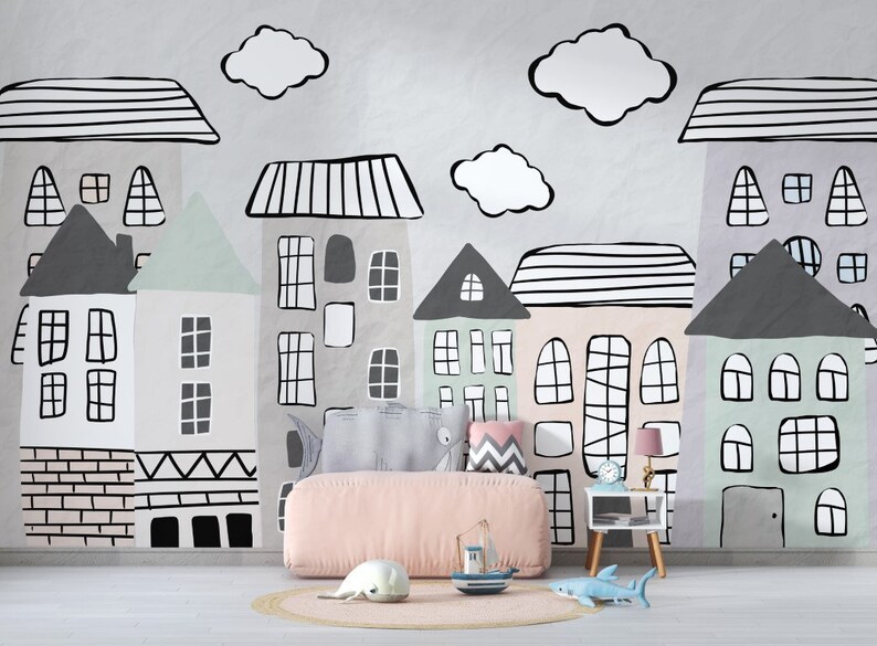 May include: A pink upholstered bed with a white and gray patterned headboard, placed in front of a wall with a black and white illustration of a city skyline. The illustration features houses with windows and doors, and clouds.