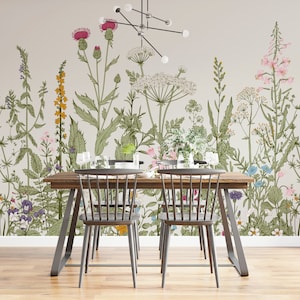 May include: A dining room with a floral wallpaper featuring a variety of flowers and plants in shades of pink, yellow, green, and blue. A wooden table with two black chairs is in the foreground.