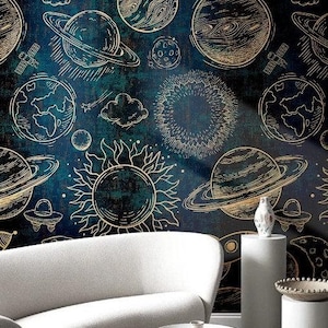 Op de afbeelding: Een gebogen witte bank staat voor een donkerblauwe muur met een herhalend gouden lijnpatroon van planeten, sterren, zonnen, raketten en vliegende schotels. Een kleine witte ronde tafel en twee witte cilindervormige sokkels staan ervoor.