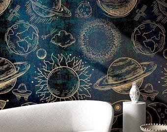 Puede incluir: Un sofá blanco curvo frente a una pared azul oscuro con un patrón repetitivo de líneas doradas de planetas, estrellas, soles, cohetes y platillos voladores. Una pequeña mesa redonda blanca y dos pedestales cilíndricos blancos al frente.