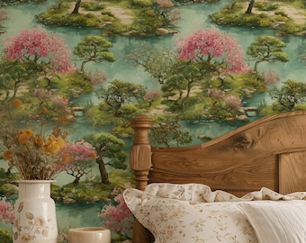 May include: Wallpaper featuring a repeating landscape pattern of pink cherry blossom trees, green islands, and small stone bridges over water. A wooden bed frame with floral patterned pillows and a white quilt sits in front of the wallpaper.