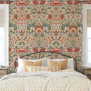 Puede incluir: Un dormitorio con una cama que presenta una cabecera con estampado y un papel tapiz floral con acentos rojos, azules y verdes. La cama tiene un edred&oacute;n blanco y almohadas con estampado amarillo.