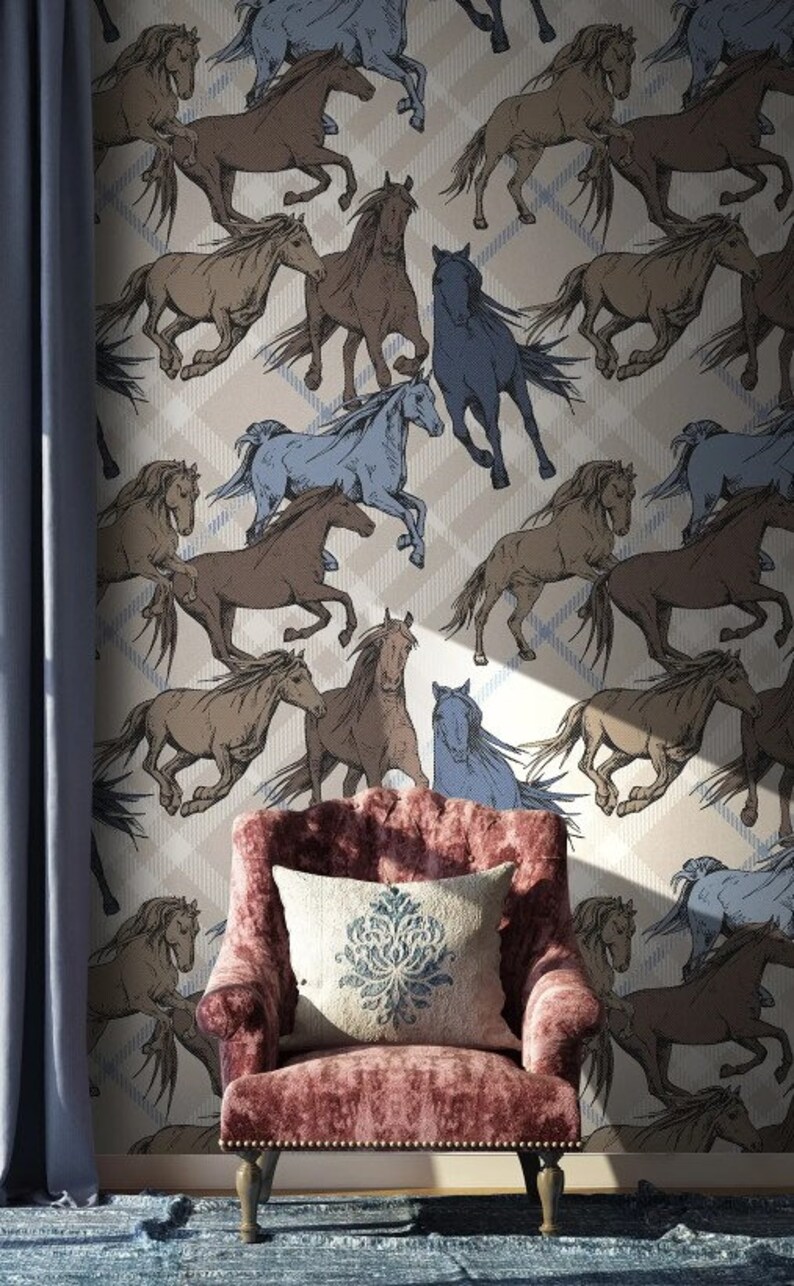 May include: A beige wallpaper with a repeating pattern of brown and blue horses running in different directions. The wallpaper is in a room with a pink armchair and a blue rug.