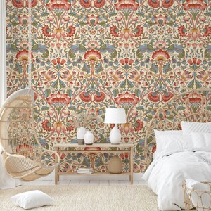 Puede incluir: Un interior de dormitorio con un papel tapiz estampado que presenta un dise&ntilde;o floral en tonos rojos, verdes y azules. El papel tapiz es un patr&oacute;n repetitivo de flores y hojas estilizadas. Una cama blanca con una funda n&oacute;rdica blanca est&aacute; en primer plano. Una silla colgante de mimbre est&aacute; en el fondo. Una mesa de madera con una l&aacute;mpara y dos jarrones est&aacute; en el centro de la habitaci&oacute;n.