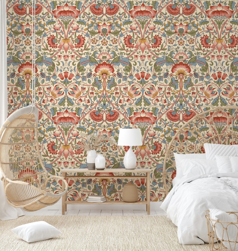 Puede incluir: Un interior de dormitorio con un papel tapiz estampado que presenta un dise&ntilde;o floral en tonos rojos, verdes y azules. El papel tapiz es un patr&oacute;n repetitivo de flores y hojas estilizadas. Una cama blanca con una funda n&oacute;rdica blanca est&aacute; en primer plano. Una silla colgante de mimbre est&aacute; en el fondo. Una mesa de madera con una l&aacute;mpara y dos jarrones est&aacute; en el centro de la habitaci&oacute;n.
