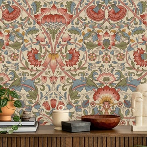 Puede incluir: Un papel tapiz beige con un patr&oacute;n repetitivo de flores estilizadas en tonos rojos, azules y verdes. El papel tapiz se muestra en una habitaci&oacute;n con una mesa de madera y varios objetos decorativos.