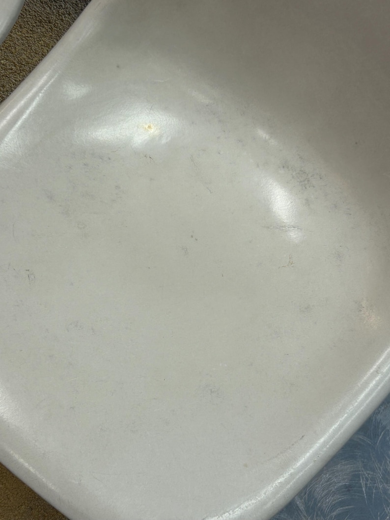 Pode incluir: Assento de cadeira de pl&aacute;stico branco com alguns arranh&otilde;es e marcas leves.