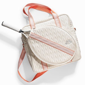 Tennis bag in quilted white vegan leather with orange webbing and solid golden metal pullers.