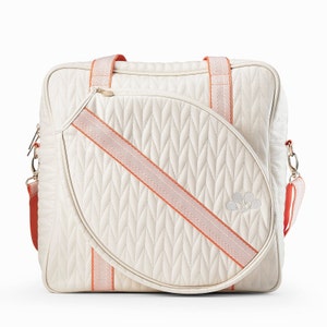 Tennis bag in quilted white vegan leather with orange webbing and solid golden metal pullers.