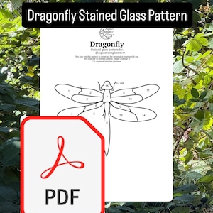 May include: A white PDF document featuring a dragonfly stained glass pattern. The design includes numbered sections for cutting and assembly. The document is labeled "Dragonfly Stained Glass Pattern" and includes the creator's handle.