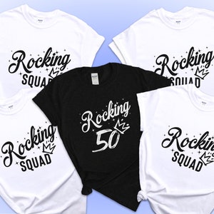 May include: Four white t-shirts with black text that says "Rocking Squad" and a crown. One black t-shirt with white text that says "Rocking 50" and a crown.