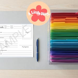 Può includere: Una scheda di memoria scolastica 12th Grade bianca con righe vuote per i dettagli personali, una penna a sfera blu e un organizer in acrilico trasparente pieno di cartelle color arcobaleno disposte in uno spettro dal rosso al viola.