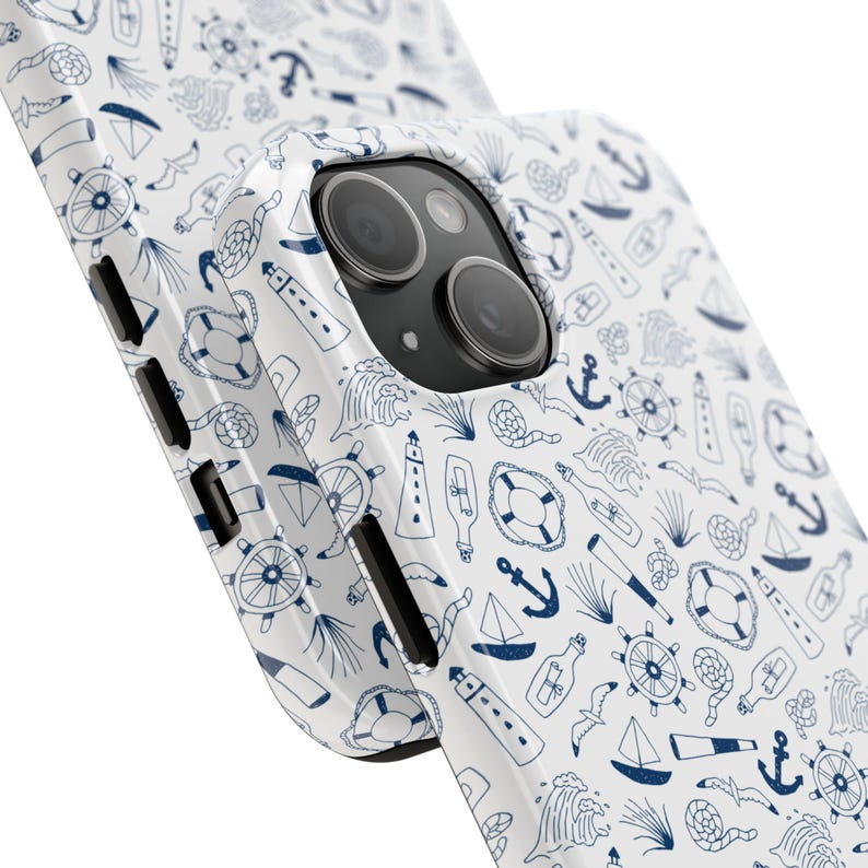 Puede incluir: Funda de tel&eacute;fono blanca con un dise&ntilde;o n&aacute;utico. El patr&oacute;n presenta ilustraciones azules de anclas, veleros, salvavidas y faros. La funda es brillante y envuelve el tel&eacute;fono, mostrando la c&aacute;mara y los botones laterales.
