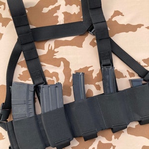 Puede incluir: Chaleco táctico negro con cinco bolsas para cargadores y correas de hombro ajustables. El chaleco está diseñado para llevar cinco cargadores.