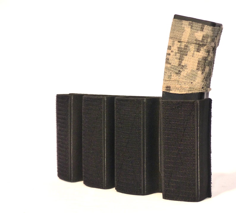 May include: A black tactical magazine pouch with four slots for holding magazines. A camouflage-patterned magazine is inserted into one of the slots.