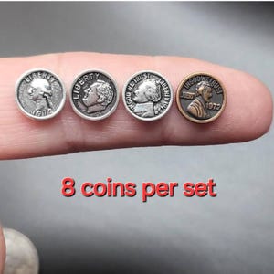 May include: A set of eight miniature coins, featuring different designs and dates, including a silver coin with the inscription "Liberty 1972".