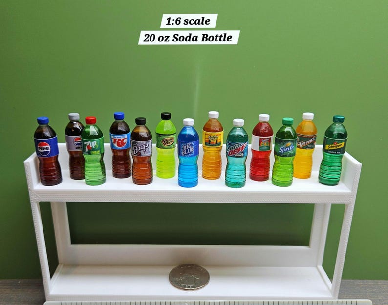Puede incluir: Botellas de refresco en miniatura de varias marcas y colores, incluyendo Pepsi y Sprite, exhibidas en una estanter&iacute;a blanca. Las botellas est&aacute;n etiquetadas como "20 oz" y son a escala 1:6. El fondo es verde liso.