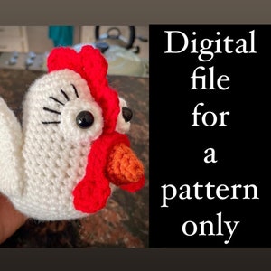 May include: A crocheted chicken amigurumi toy with white body, red comb and wattle, and orange beak. The toy has black eyes and eyelashes. The image text reads "Digital file for a pattern only".