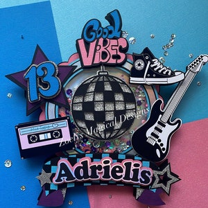 May include: A birthday cake topper with a disco ball, a guitar, a pair of sneakers, a cassette tape, a star with the number 13, and a banner that says "Good Vibes" and "Adrielis".