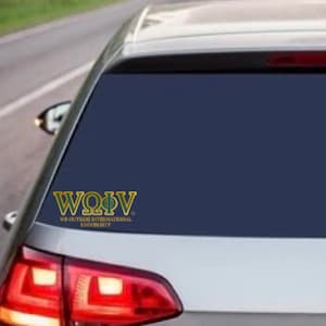 May include: A gold and navy blue car sticker displaying the text "WOΦV" and "WE OUTSIDE INTERNATIONAL UNIVERSITY". The sticker is on the rear window of a silver car, with the taillight visible.