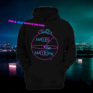 以下が含まれることがあります： 黒色のフード付きスウェットシャツ。前面にポケットが付いています。「Pink & Blue Glow in the Dark」と「God's Math Be Mathing」というピンクと青色の光る文字が円形にデザインされています。背景には都市のスカイラインと橋が描かれています。
