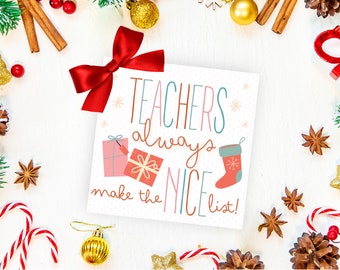 May include: A Christmas card with the message "Teachers always make the NICE list!" is surrounded by festive decorations. The card features illustrations of gifts and a stocking. A red bow sits atop the card, with cinnamon sticks, baubles, and candy canes.