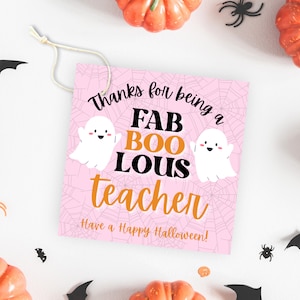 May include: Pink Halloween teacher appreciation gift tag with a spiderweb background and two white ghosts. The tag says "Thanks for being a FAB BOO LOUS teacher. Have a Happy Halloween!"