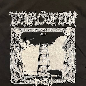 Könnte beinhalten: Schwarzes T-Shirt mit einem weißen Aufdruck der Band "FEWACOFFIN" und dem Albumtitel "TRINITY" mit einem Schwarzweißbild eines Turms und zweier Figuren.