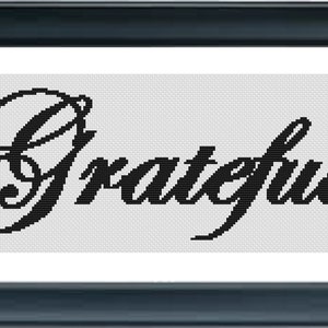 May include: Black and white cross-stitch embroidery with the word "Grateful" in a cursive font.