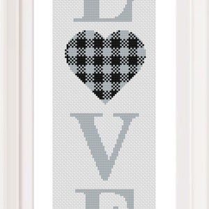 May include: A framed cross-stitch design with the word "LOVE" in gray letters and a black and white checkered heart in the center.