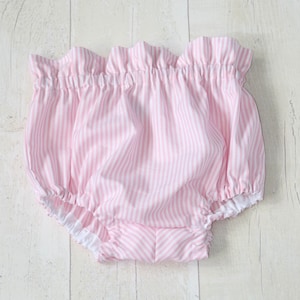 May include: Pink and white striped baby bloomers with a ruffled edge.
