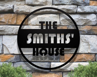 May include: Black metal sign with the text "The Smiths' House" in a circle.