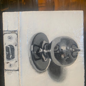 May include: A close-up of a painted door knob against a white background. The door knob is silver and has a black handle. The door knob is painted in a realistic style.