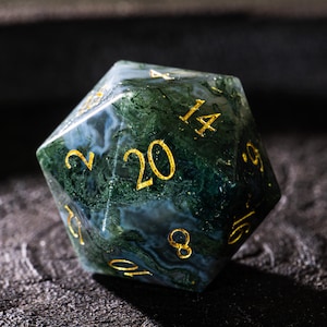 Pu&ograve; includere: Un dado a venti facce con un motivo marmorizzato verde e bianco. I numeri sono dorati. Questo dado insolito &egrave; progettato per i giochi di ruolo da tavolo. Il dado misura circa 4 cm di diametro.