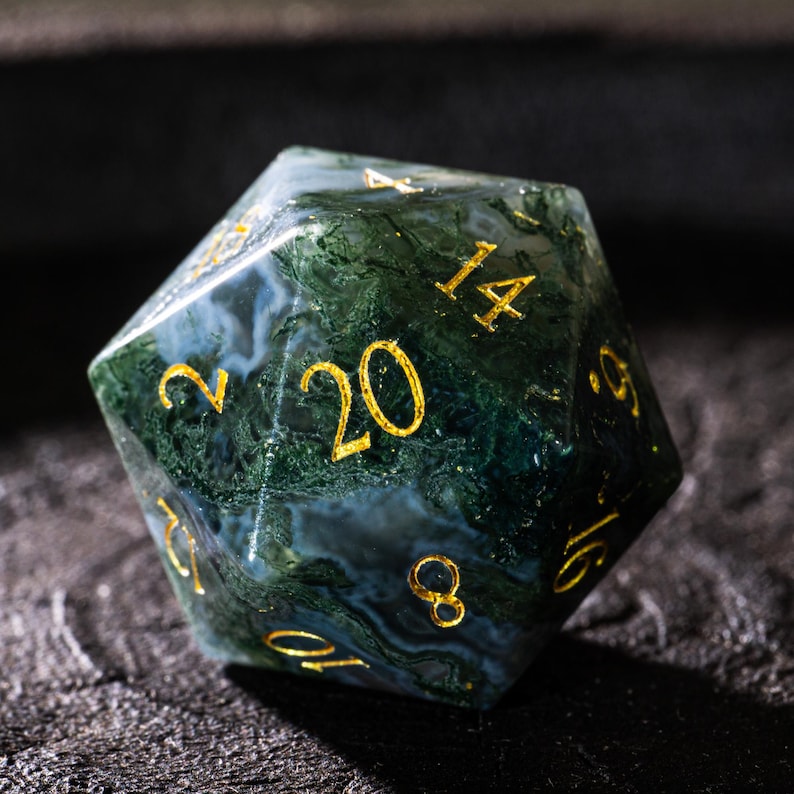Pu&ograve; includere: Un dado a venti facce con un motivo marmorizzato verde e bianco. I numeri sono dorati. Questo dado insolito &egrave; progettato per i giochi di ruolo da tavolo. Il dado misura circa 4 cm di diametro.