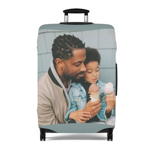 May include: A luggage cover with a photo of a father and son enjoying ice cream cones. The photo is printed on a light blue background.