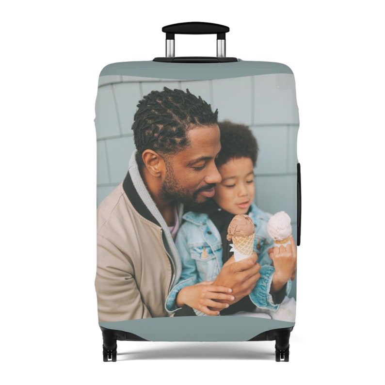 May include: A luggage cover with a photo of a father and son enjoying ice cream cones. The photo is printed on a light blue background.