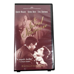 Può includere: Una custodia per DVD del film "The Spiral Staircase" con una copertina marrone. La copertina presenta immagini degli attori Dorothy McGuire, George Brent ed Ethel Barrymore. Il testo "A superb thriller" è visibile.
